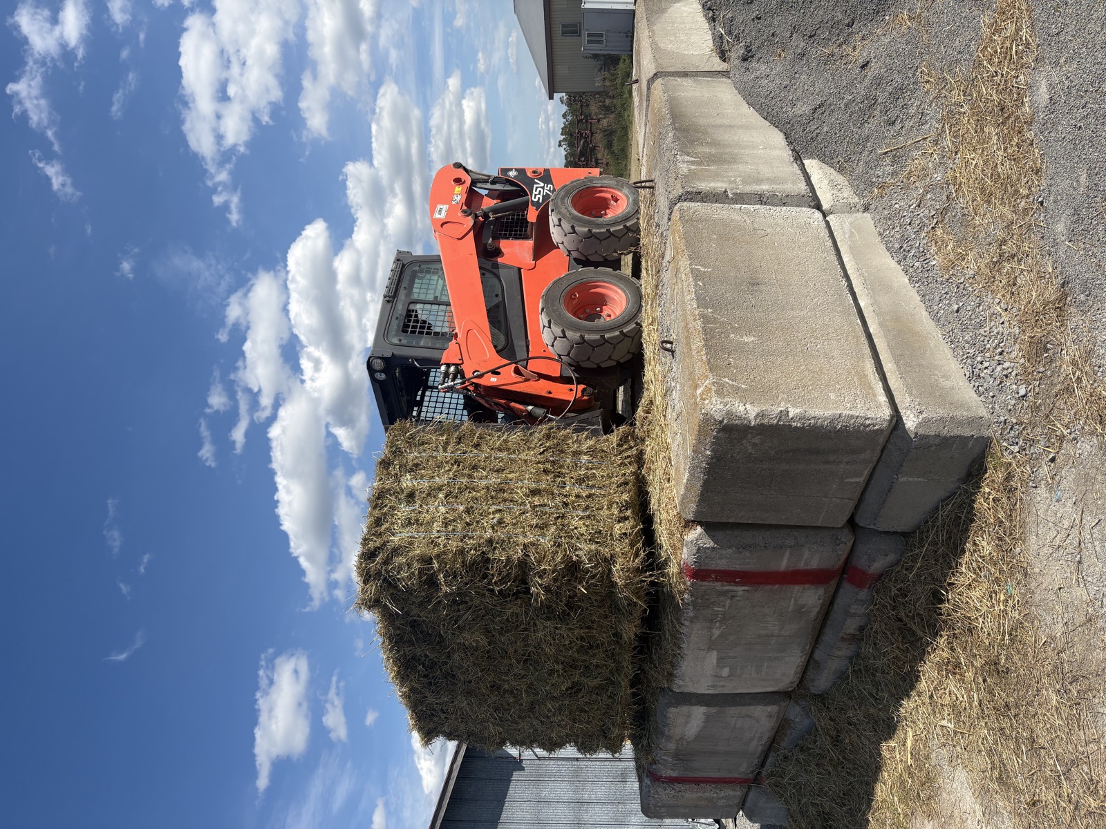 HAY 365 skid steer handling a hay bundle